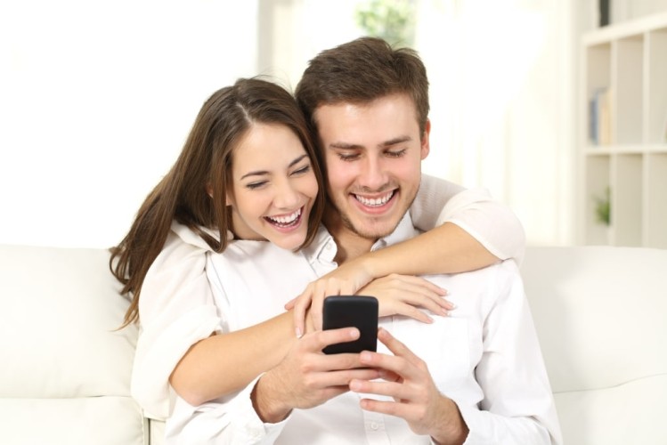 Funny couple sharing a smart phone